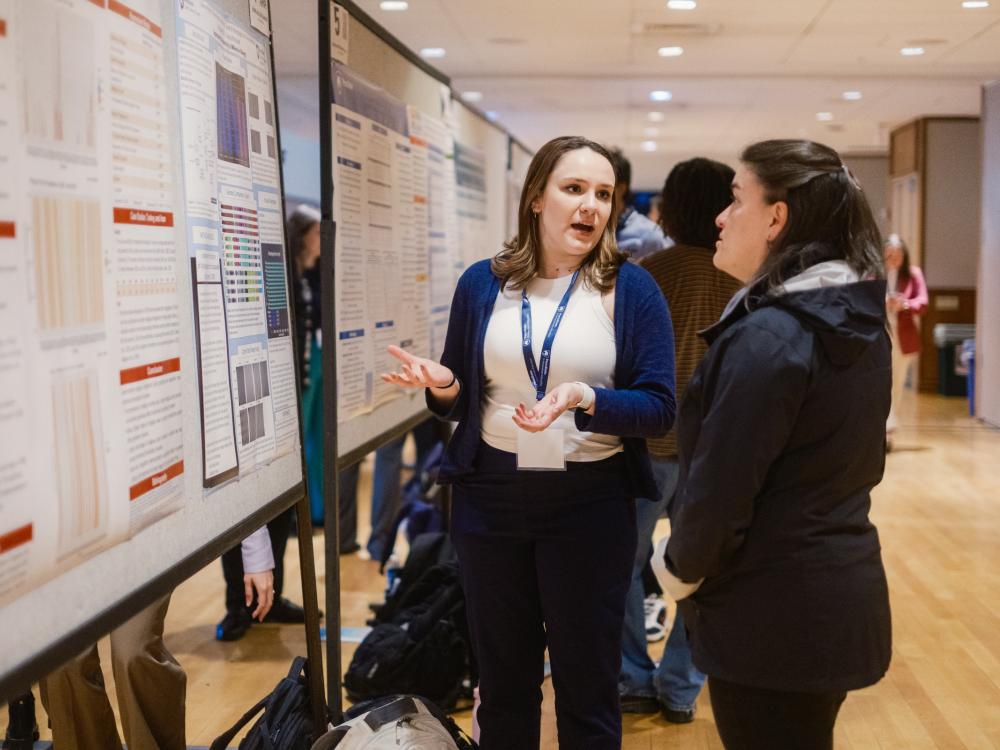 Undergraduate exhibition presenter explaining research poster