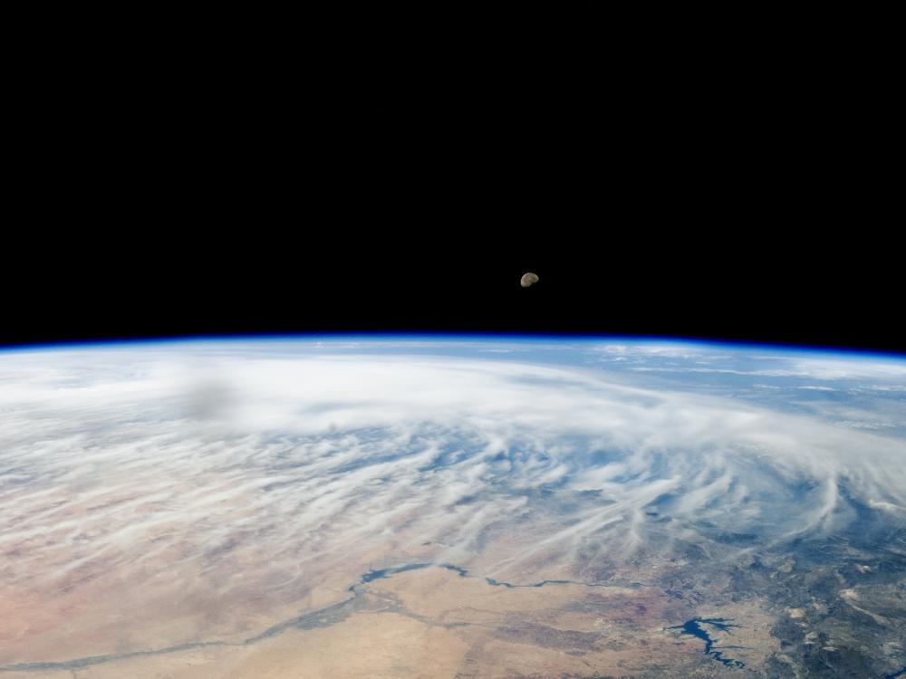 A photo taken by NASA from above the Middle East captures the Moon peeking over Earth’s atmosphere.  
