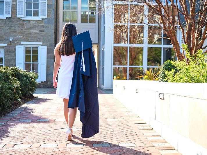graduate walking down sidewalk