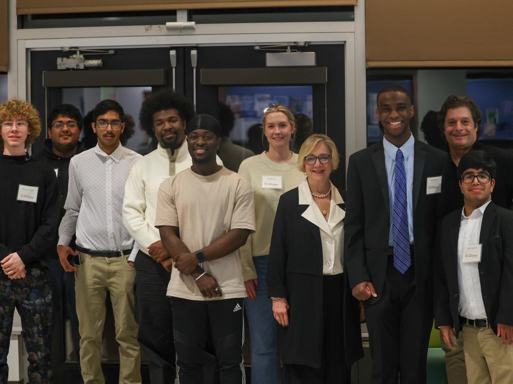 students posing for photo with administrators and coaches