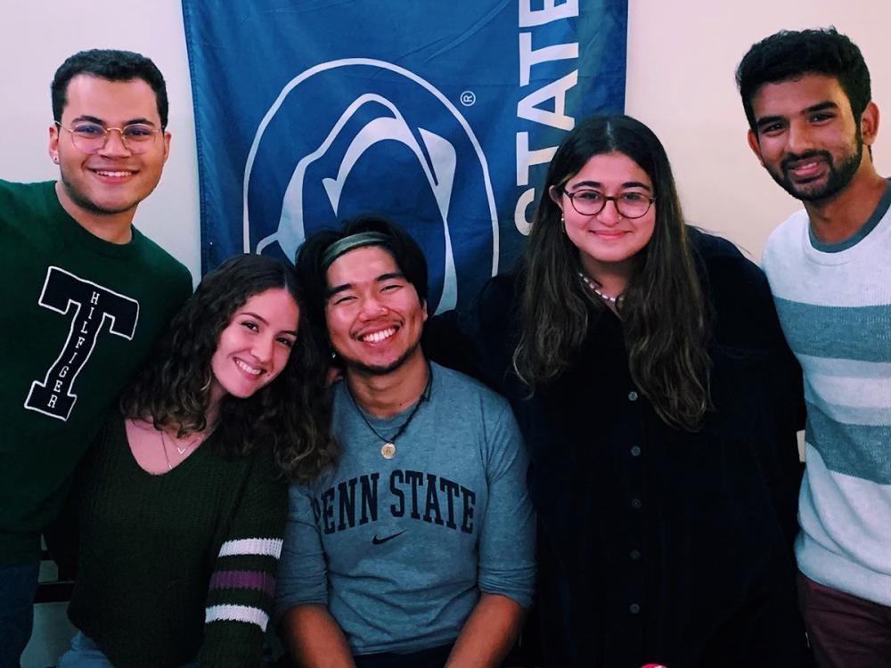 Amanda Mohamed (second from right) in front of a Penn State flag with Najee Rodriguez, Alyssa Ortiz, Anton Aluquin and Aryath Narayanamangalam.