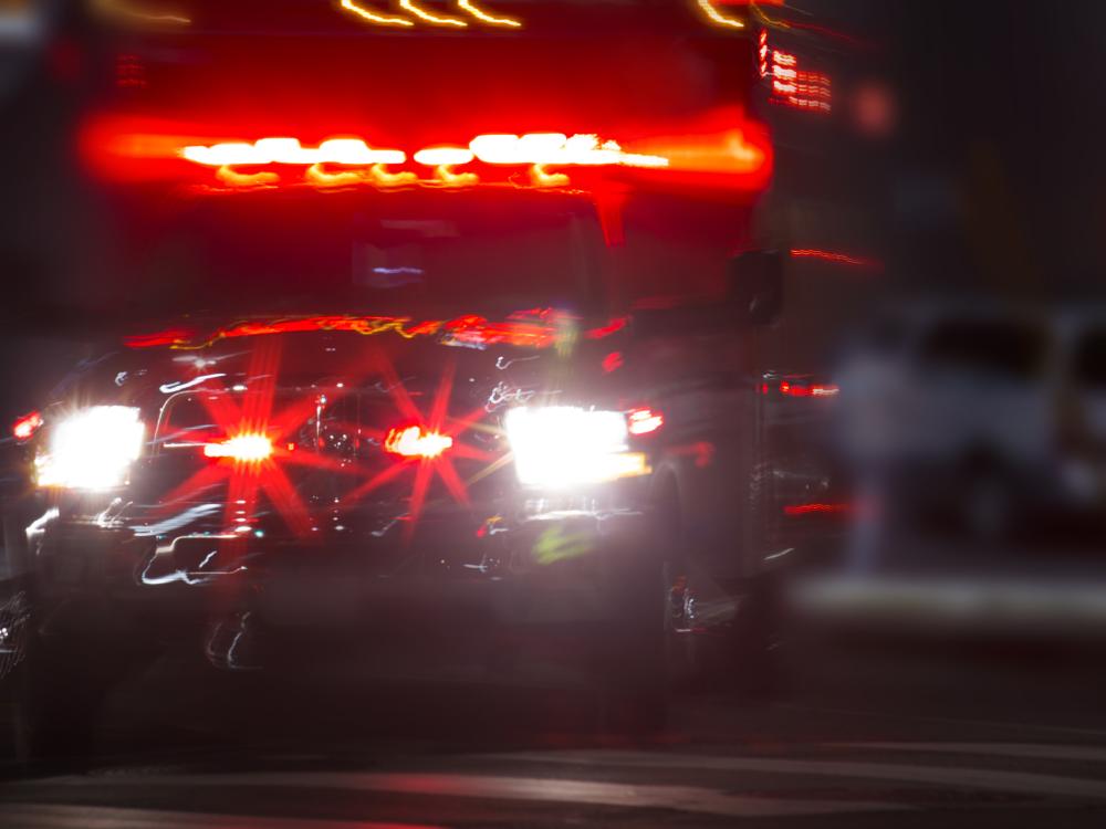 An ambulance racing through dark streets