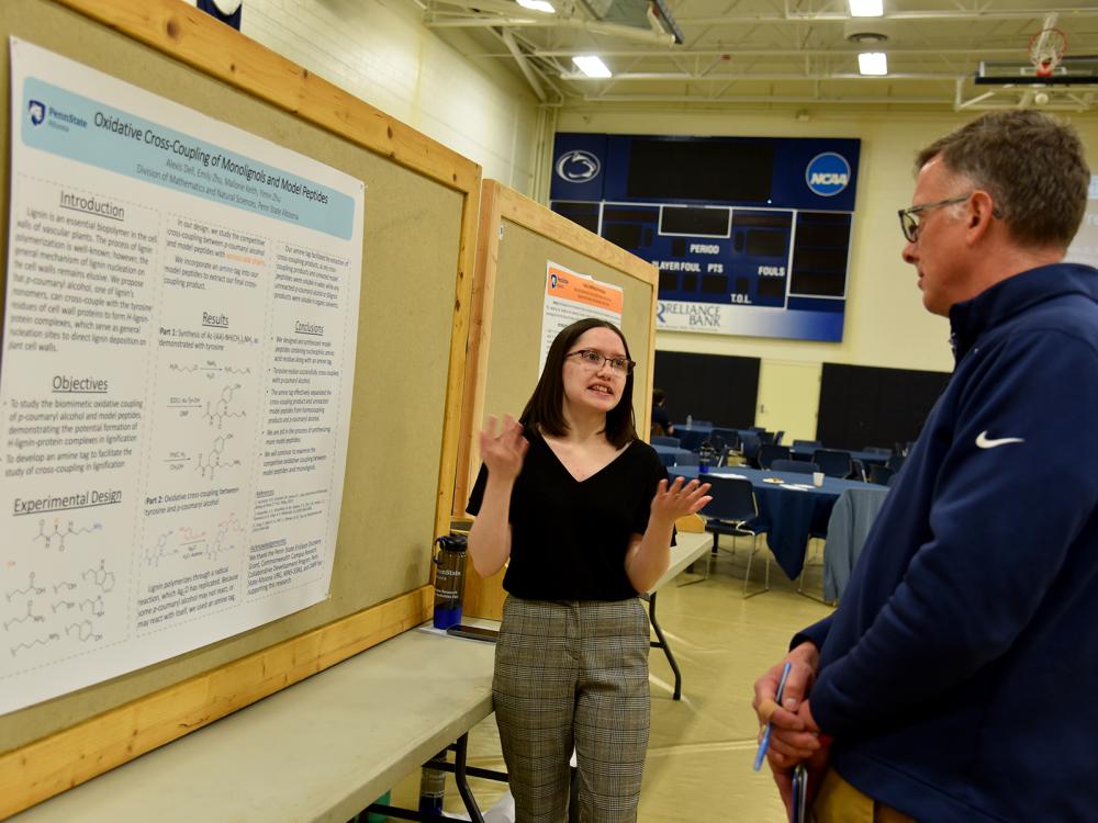 Alexis Dell explains her engineering and physical sciences research to Vice Chancellor of Academic Affairs Peter Hopsicker.