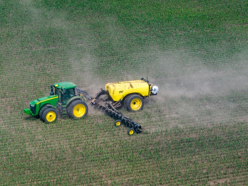 A producer applies fertilizer to a corn crop