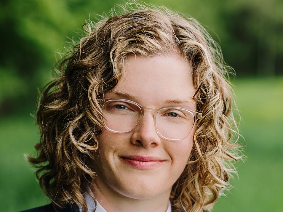 A headshot of a woman in glasses outdoors