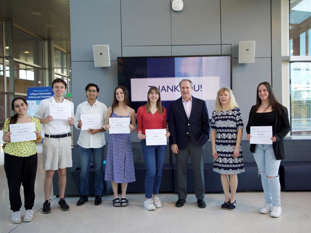eight people pose with award certificates