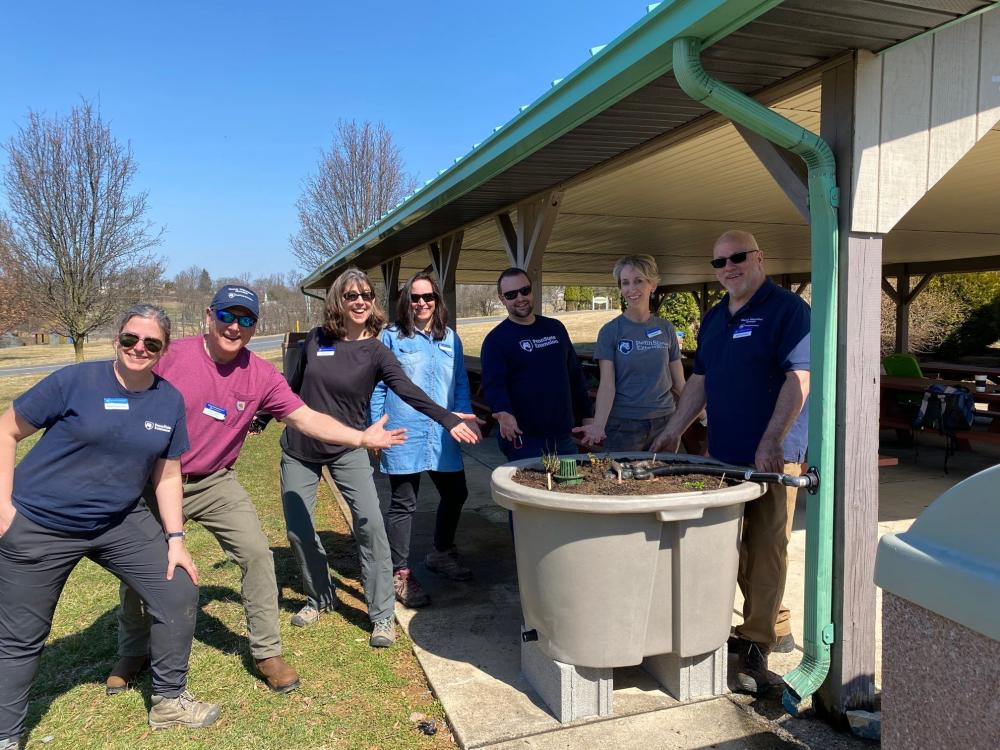 Master Watershed Steward coordinators pose with a newly installed rain barrel planter