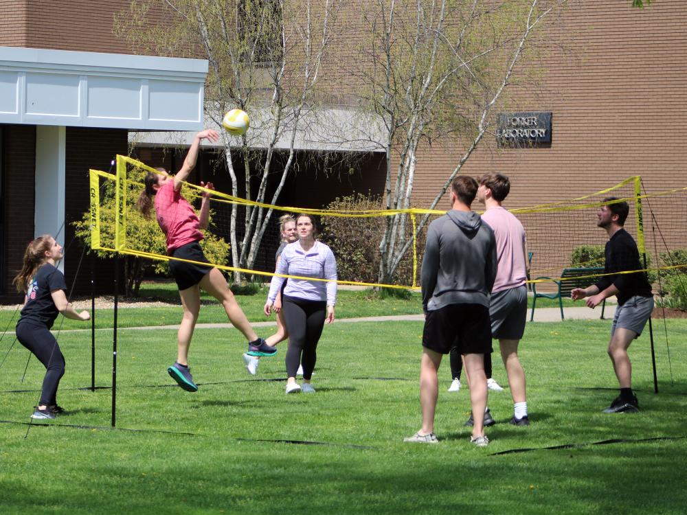 Group of student playing four square volleyball outside