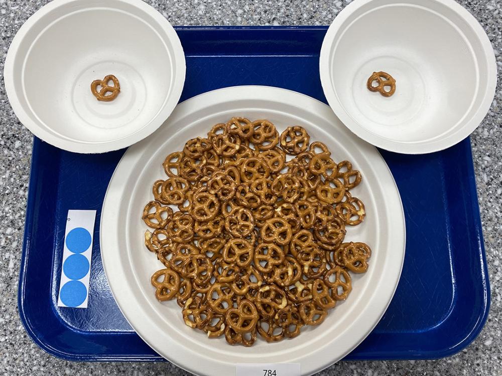 two bowls and a plate holding pretzels on a blue tray