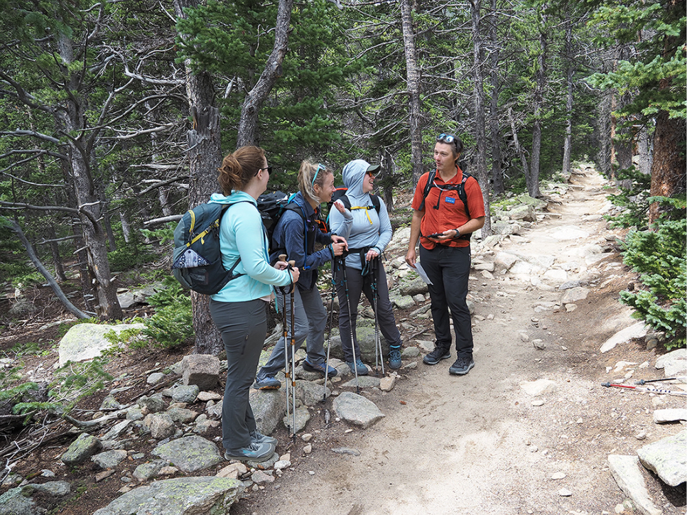 Associate Professor Derrick Taff talking with hikers on a trail