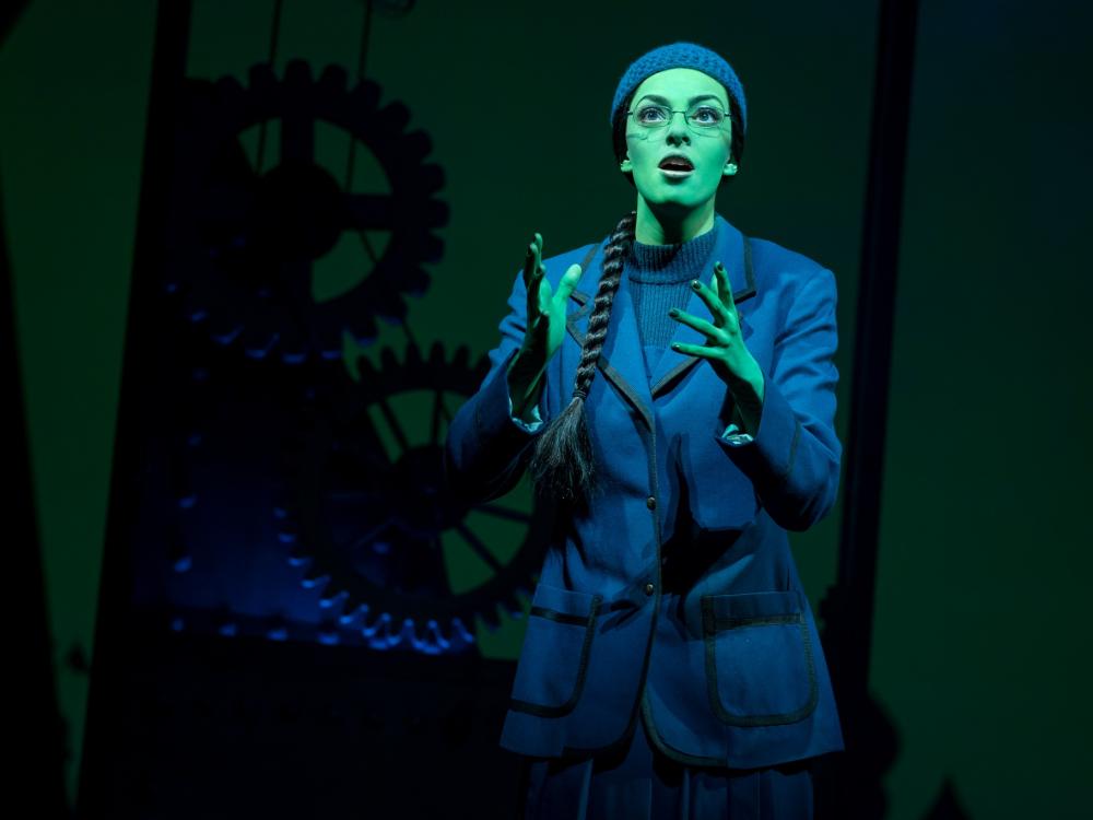 Talia Suskauer dressed in black with green skin paint as Elphaba in Broadway's Wicked