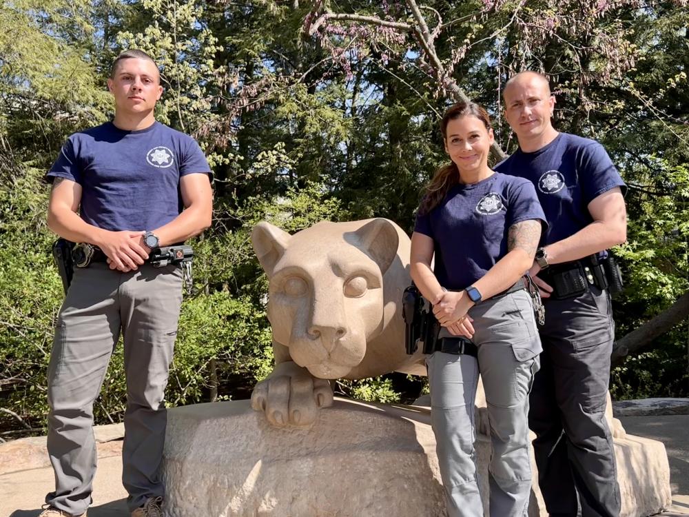 Three members of the deputy sheriff training program pose at the Nittany Lion Shrine.