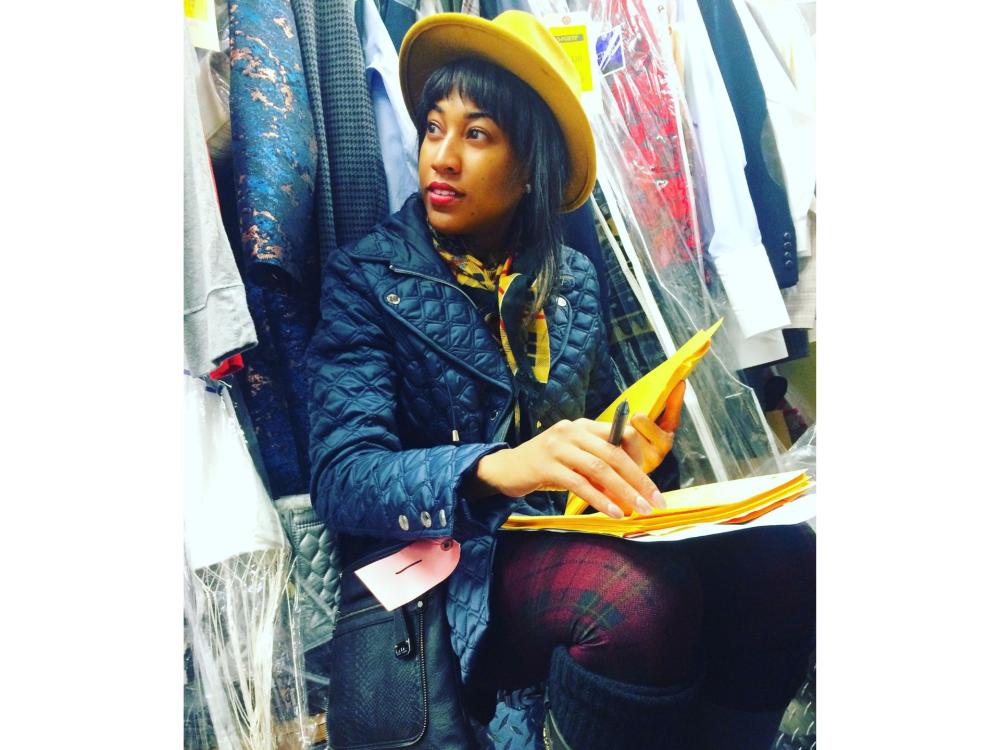 Young Black woman in colorful outfit working in a costume shop