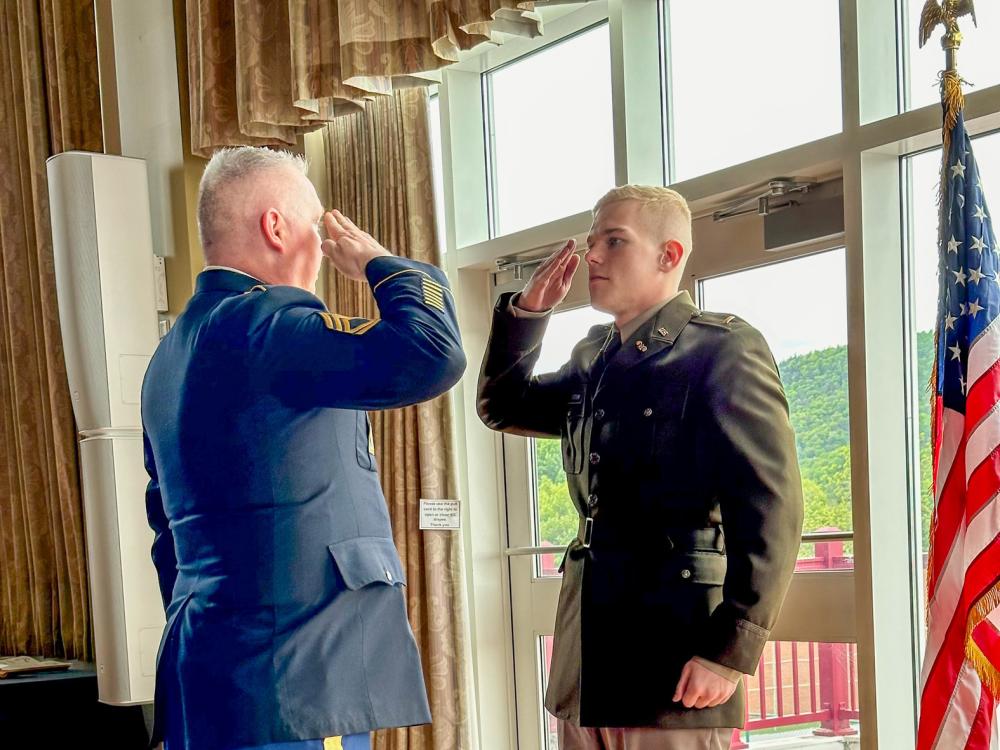 a newly commissioned officer in uniform is saluted by another person in uniform.