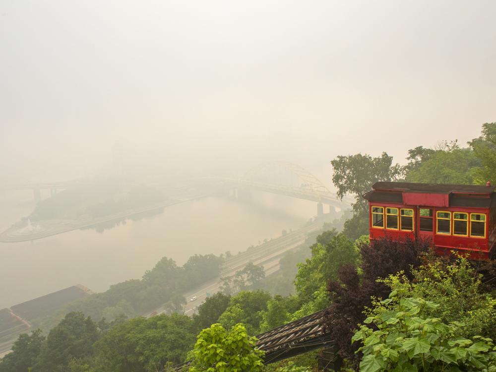 The Duquesne Incline descending a mountain, with Pittsburgh in the background obscured by wildfire smoke