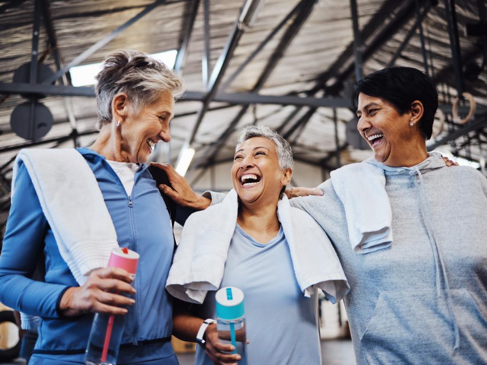 Three people smiling together in a gym