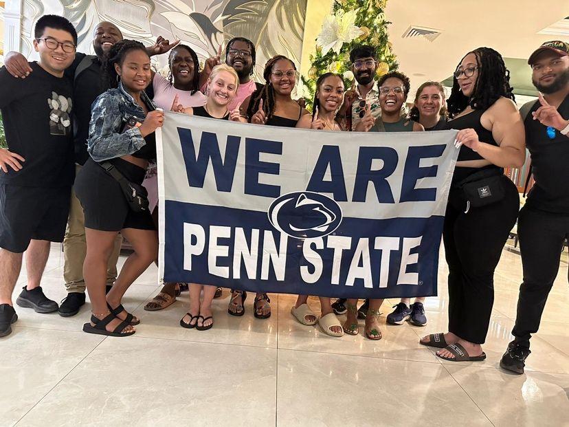 A group of people posing with a We Are Penn State sign