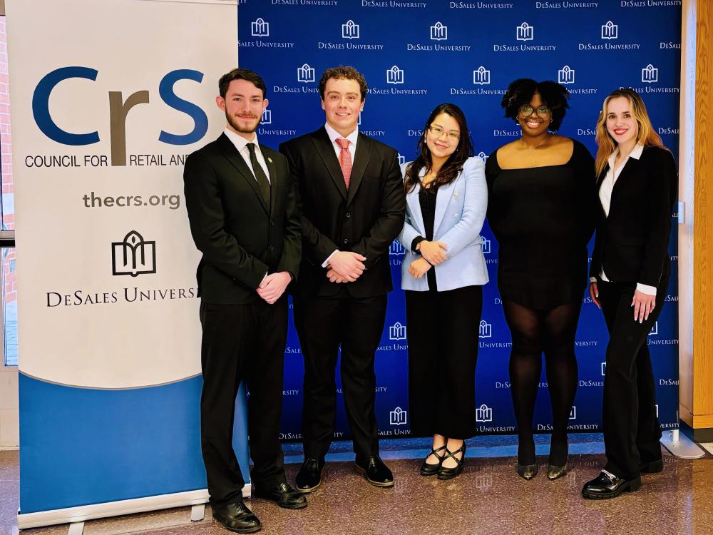Professor Emily Pham poses for a photo with her four students who participated in a business competion at DeSales University