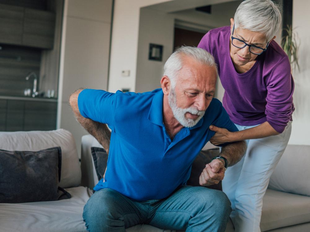 an older person helps another person change position