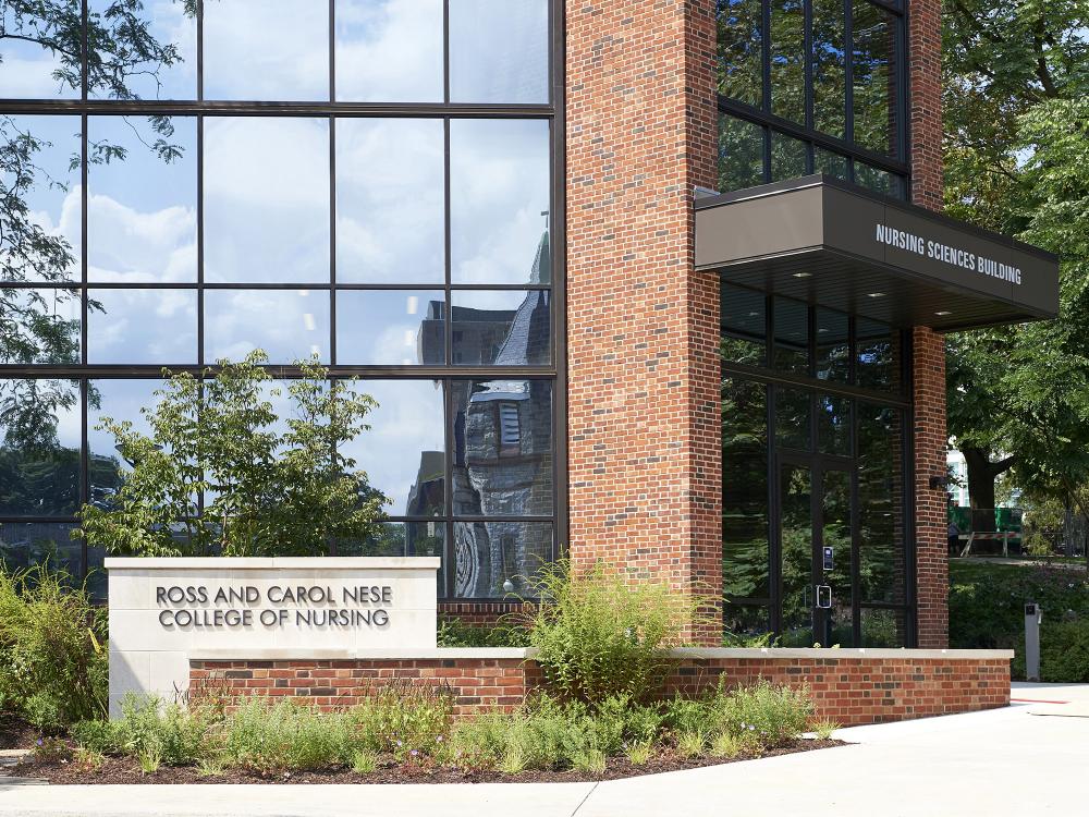 a sign that reads "Ross and Carol Nese College of Nursing: in front of a building