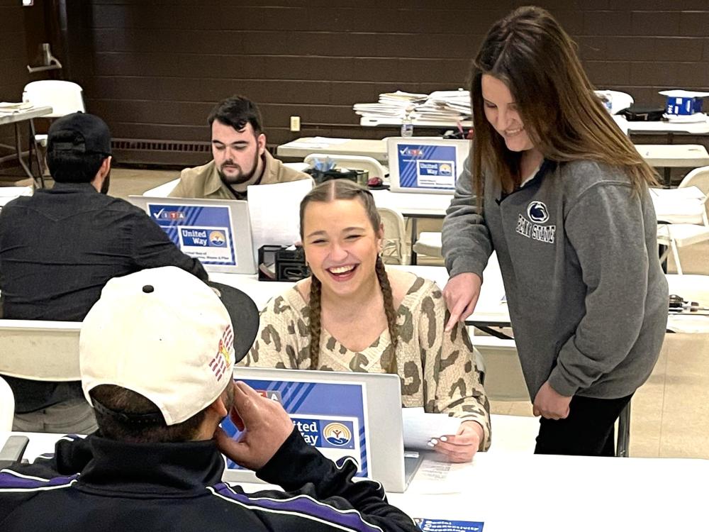 professor angela bassani assists a student during a volunteer session at VITA