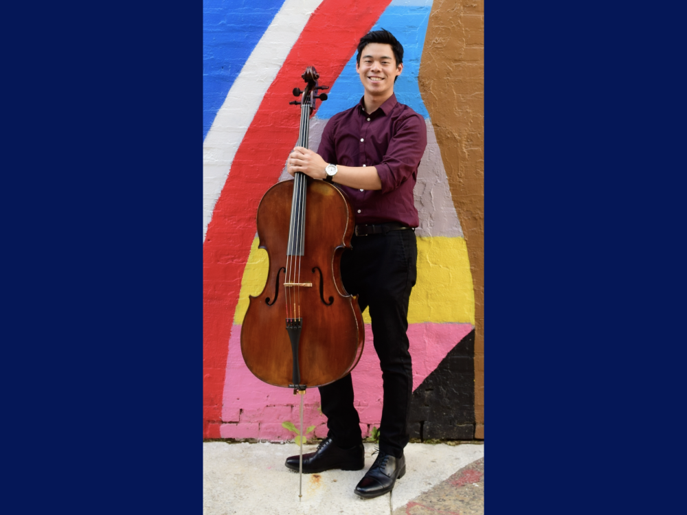 Alex Wu holding a cello, standing in front of a colorful wall