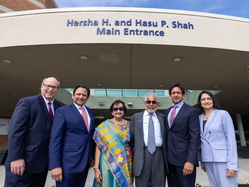 Six people in professional attire pose for a photo in front of Penn State Health Holy Spirit Medical Center.