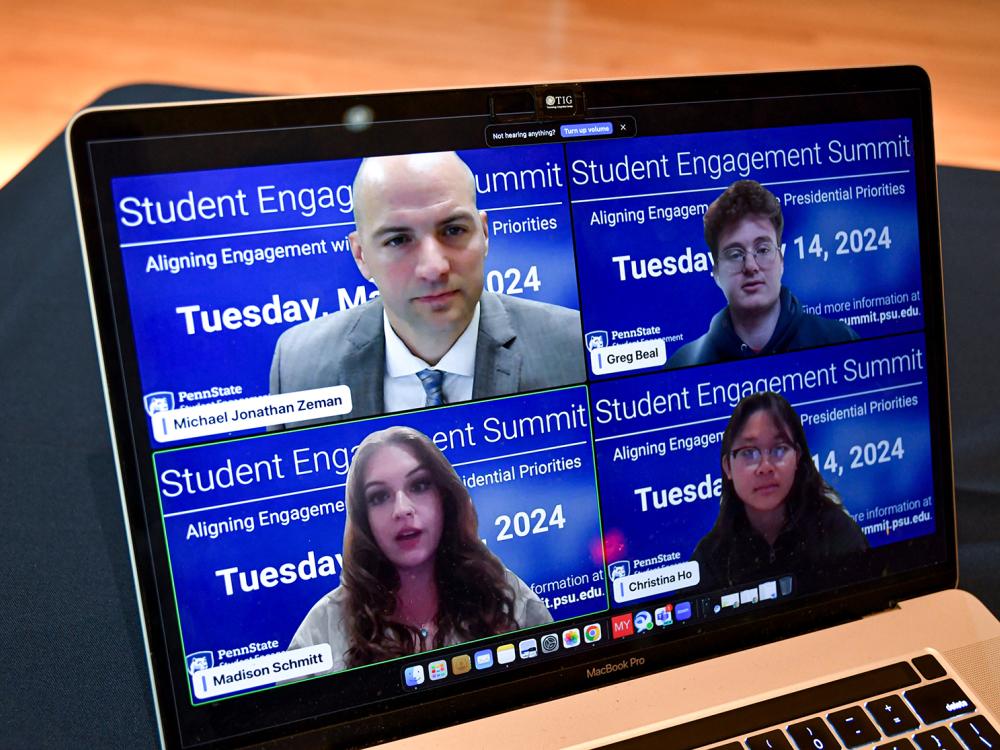 Four people in a Zoom meeting, shown on a laptop