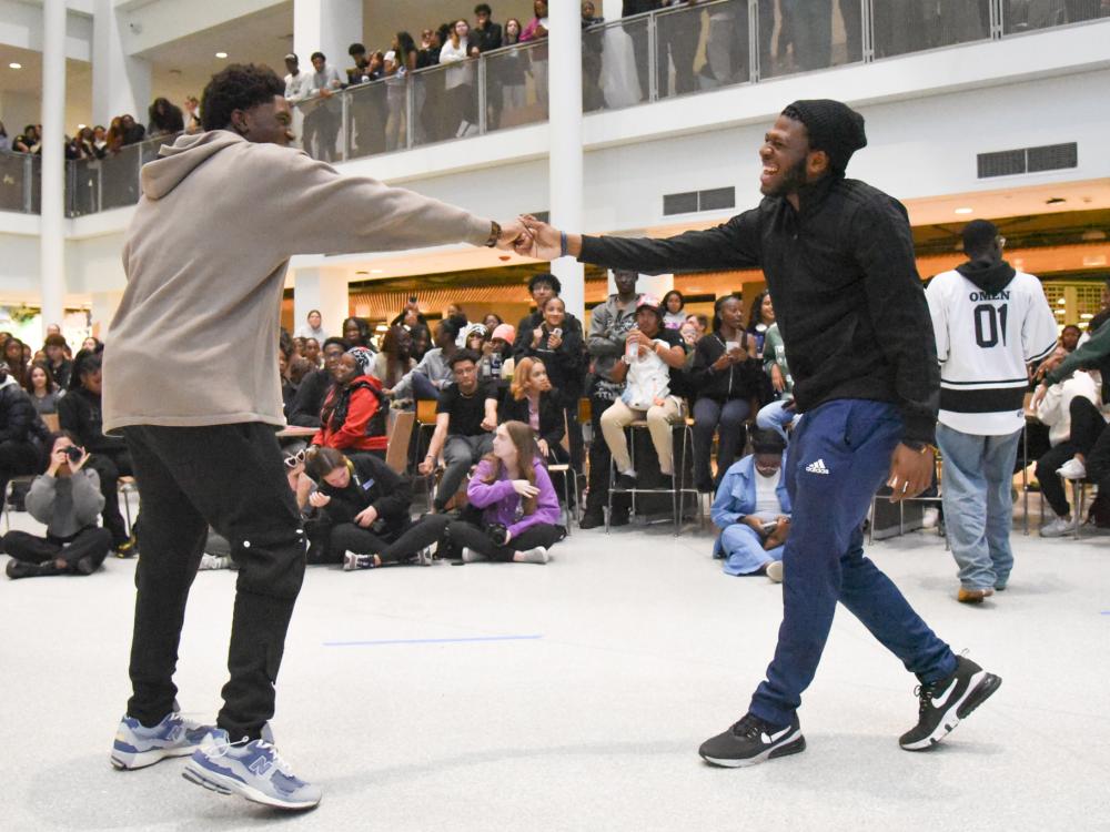 Two students bump fists while celebrating at the PRCC's annual pep rally