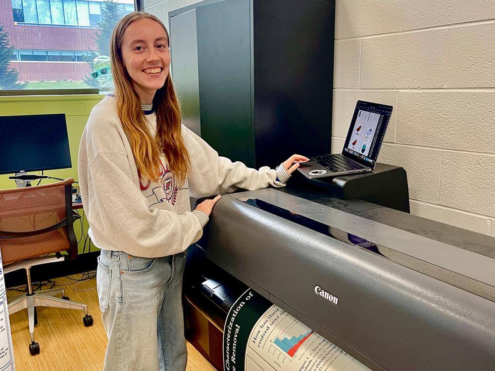 Person stands next to a printer