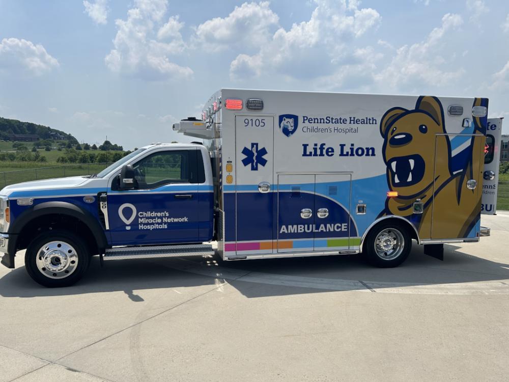 An ambulance bears the Children’s Miracle Network and Penn State Health logos and marks, as well as the likeness of a costumed Nittany Lion.