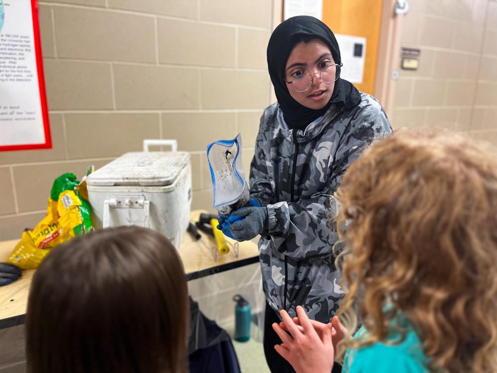 A student demonstrates a science experiment using a plastic bag