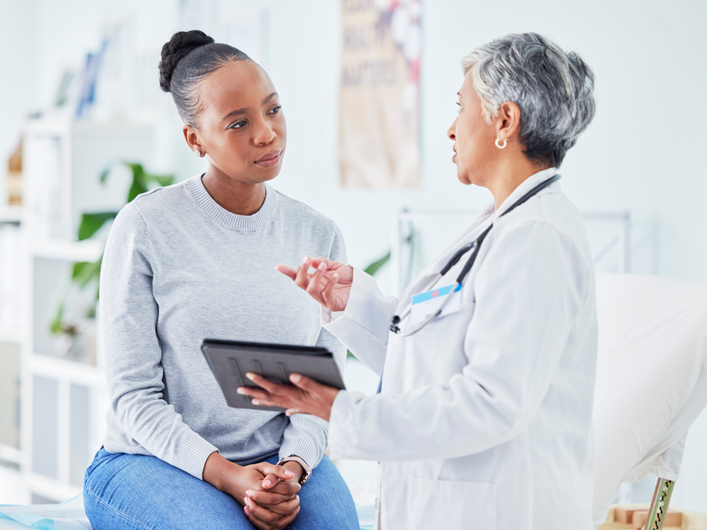 Doctor holding tablet speaking with a patient