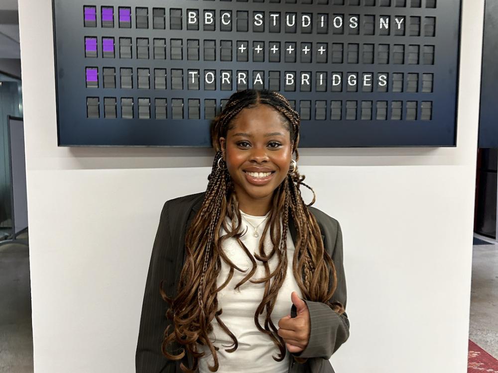 Young woman in front of BBC Studios sign