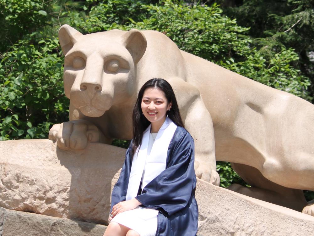 Yuki Yoshida, the student marshal for the summer 2024 semester, posing with the Nittany Lion Shrine