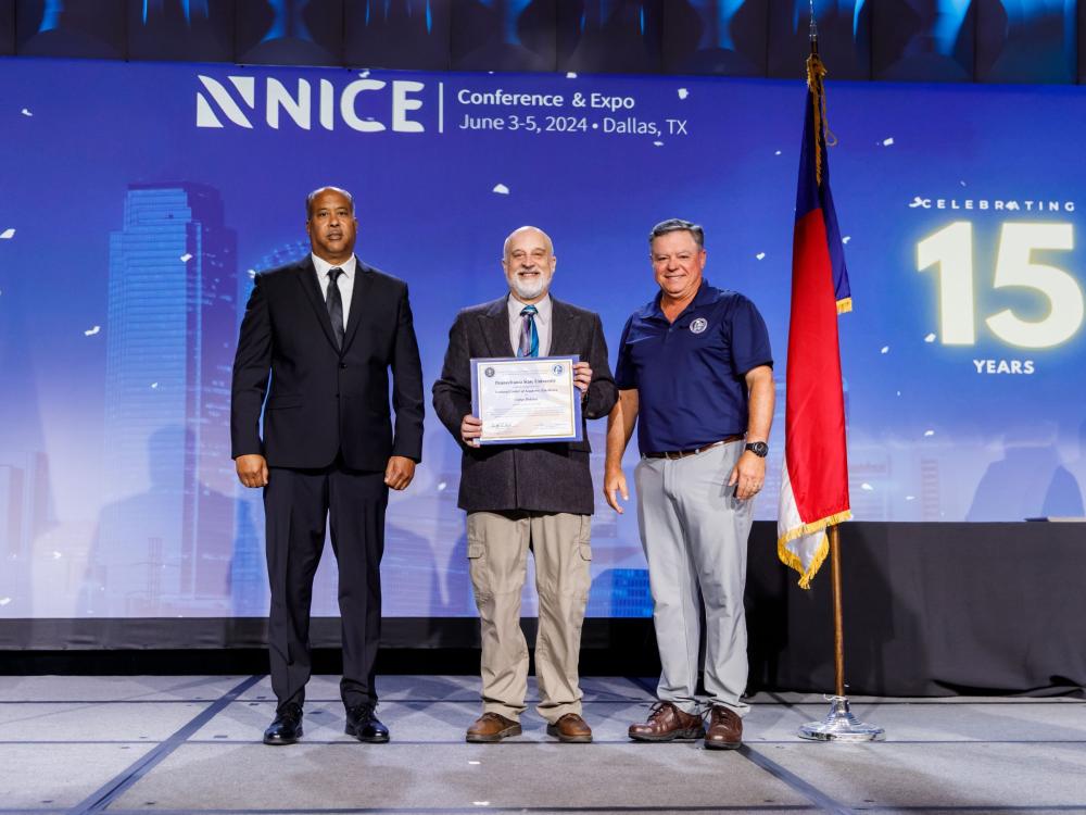 three people on stage at conference