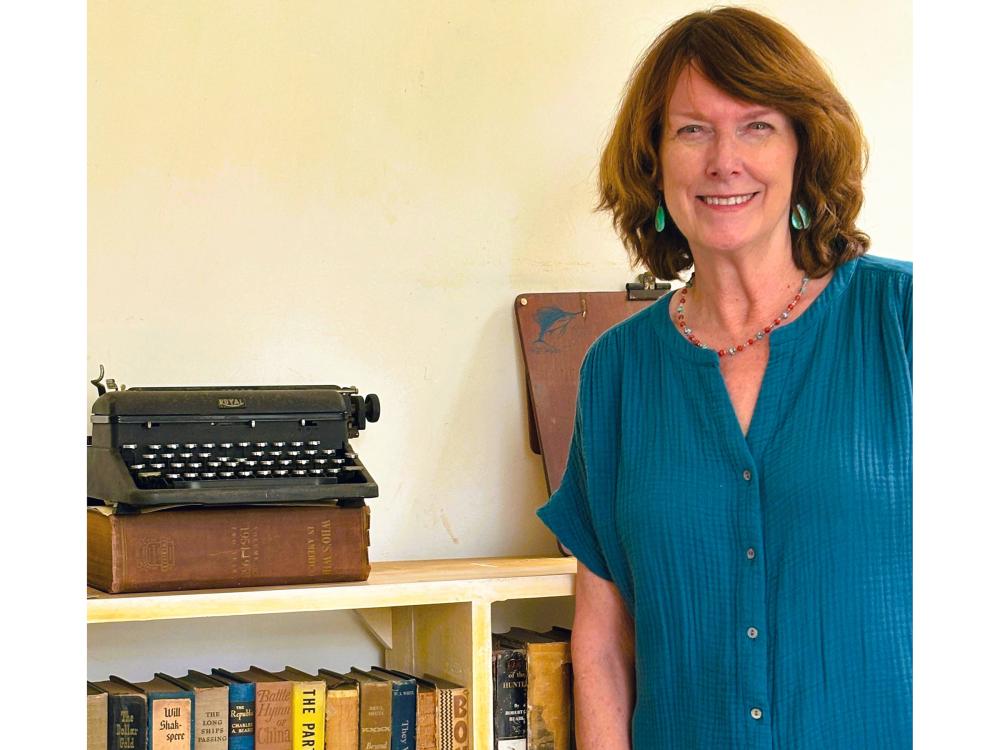 Sandra Spanier standing next to Ernest Hemingway's typewriter. 