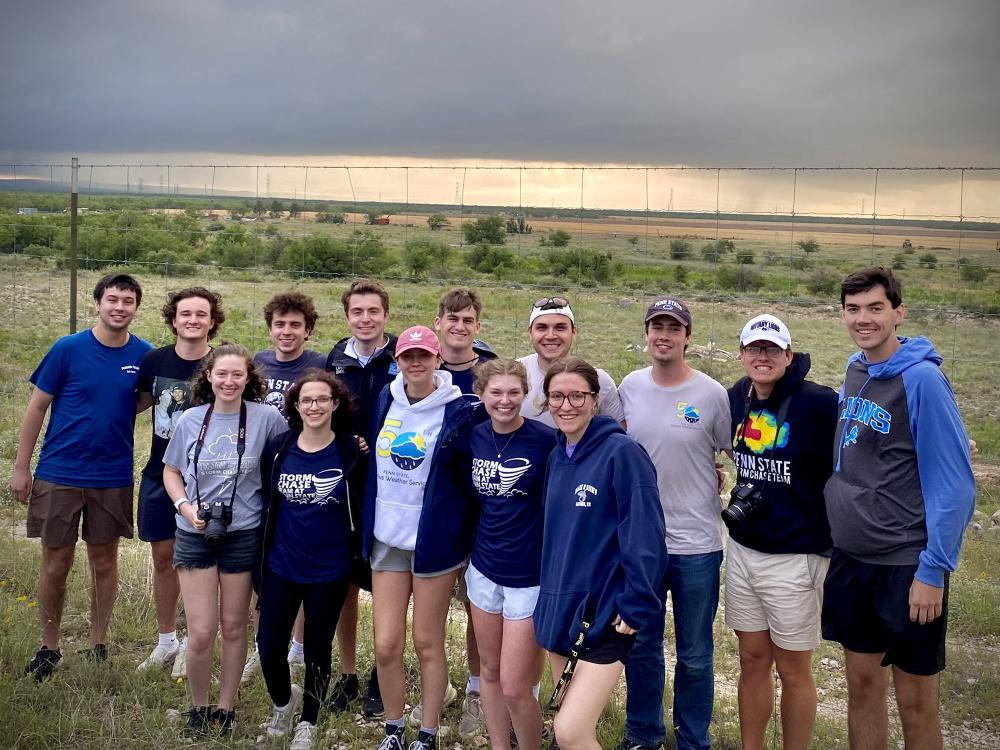 Group of people in a field with storm clouds in the background