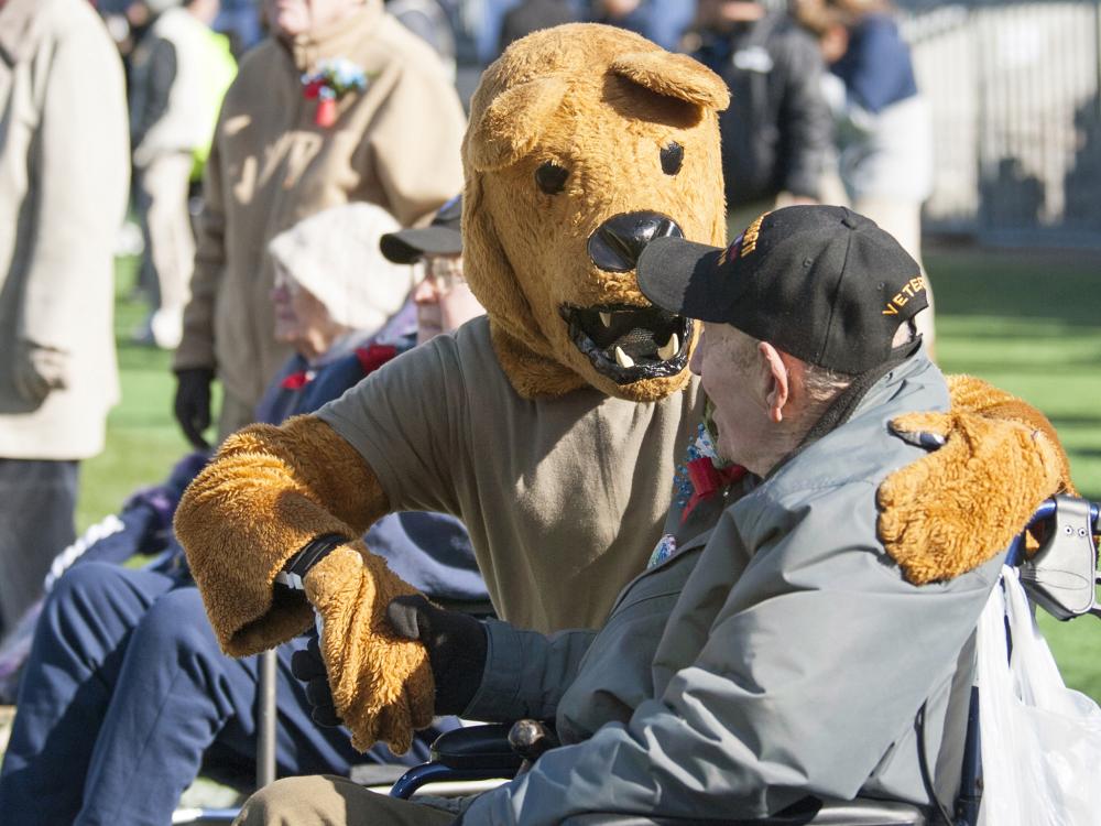 The Nittany Lion talks with World War II veteran Francis Chesko on the field of Beaver Stadium