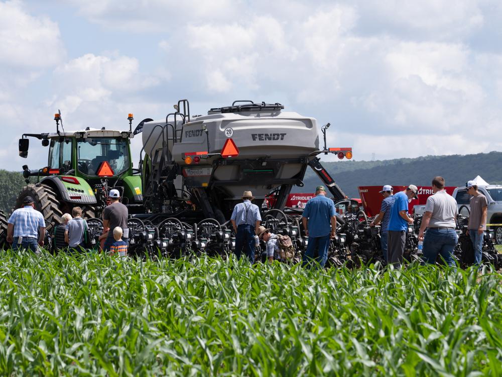 Visitors inspect a corn planter following a field machinery demonstration.