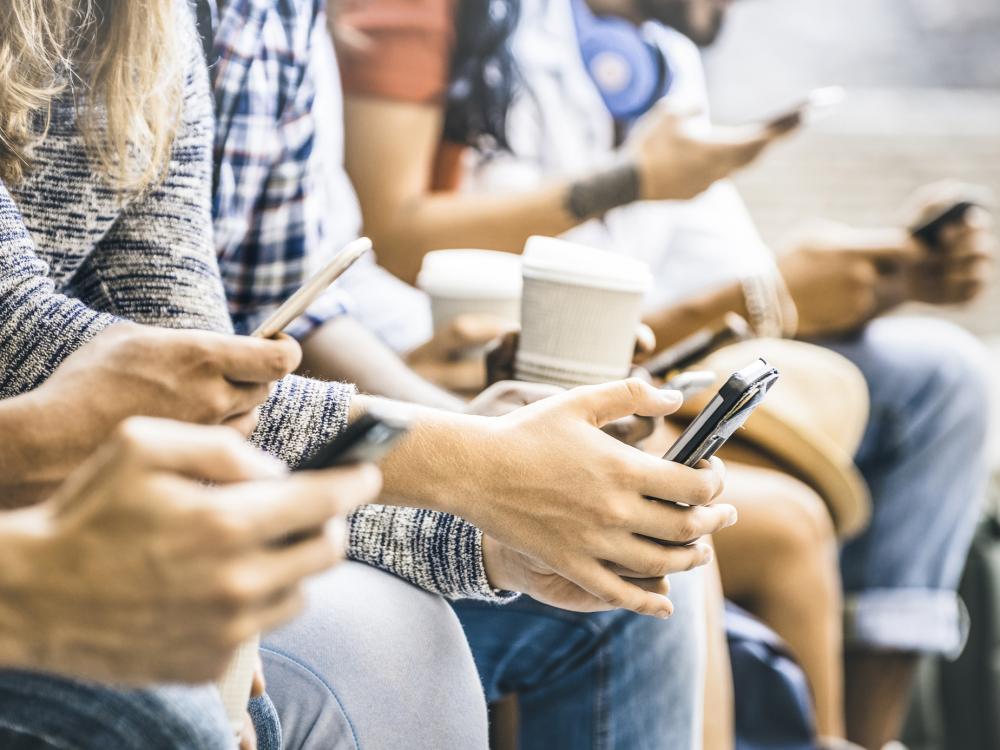 Hands holding phones and coffee