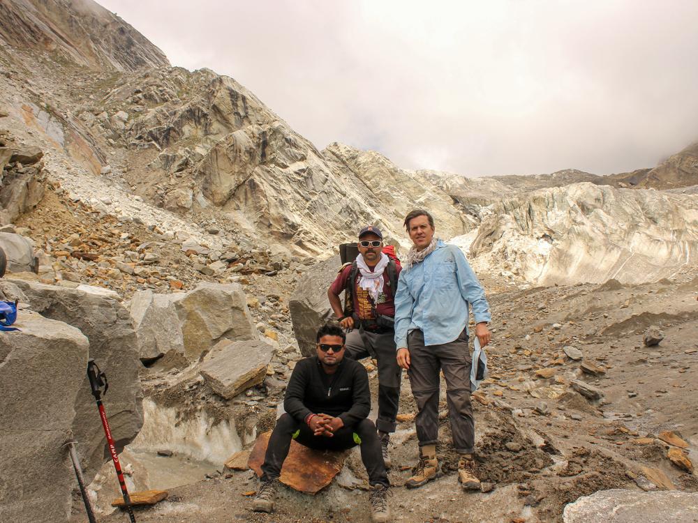 Three people in a rocky area.