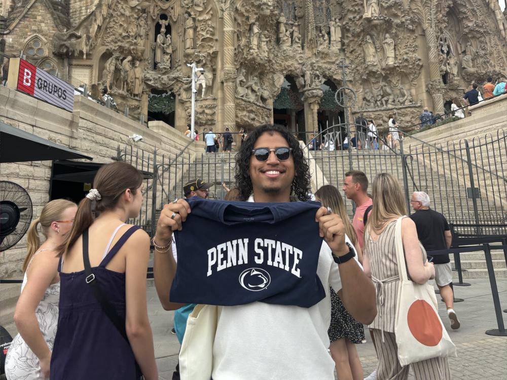 Juan Serrano holds a Penn State t-shirt in front of the Sagrada Familia in Spain