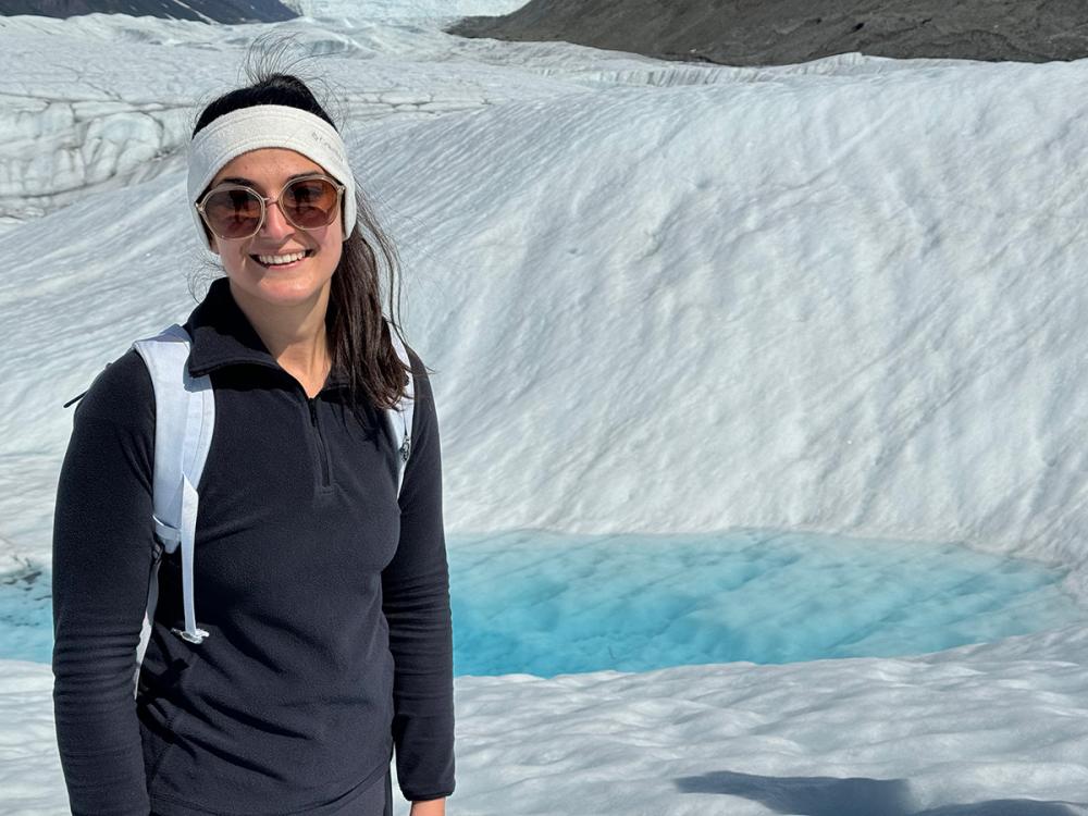 Person stands in front of a glacier