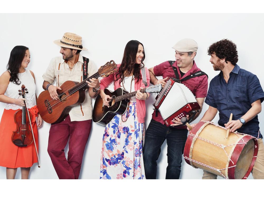 A group of five Latin American musicians hold their traditional Mexican instruments.