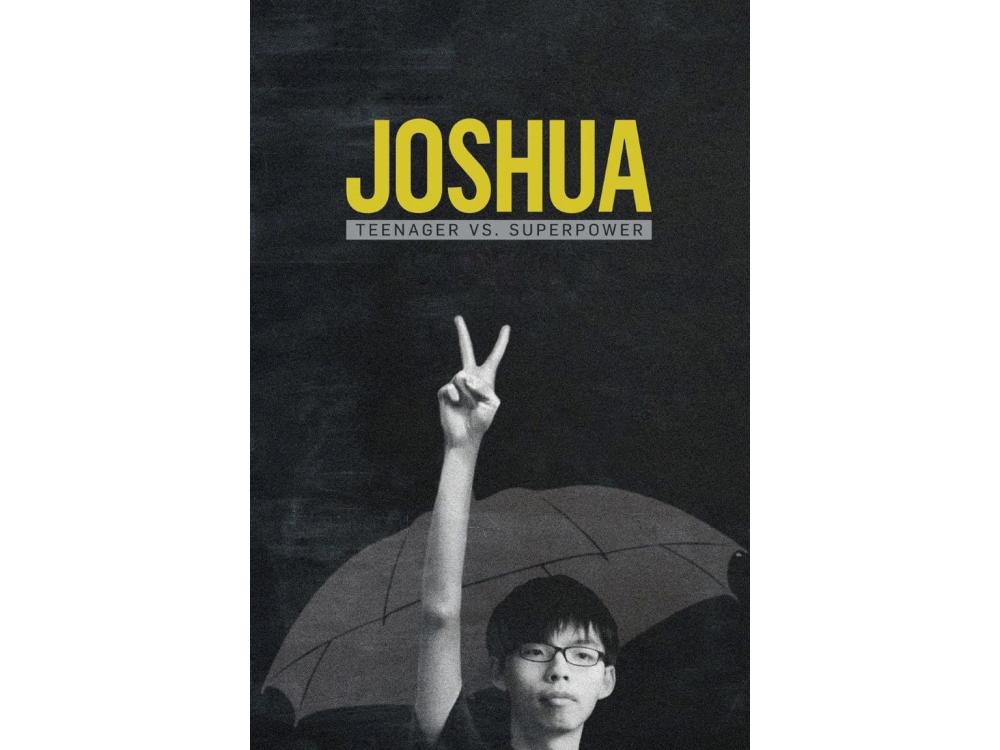 A student holds his hand up with the two-fingered peace sign