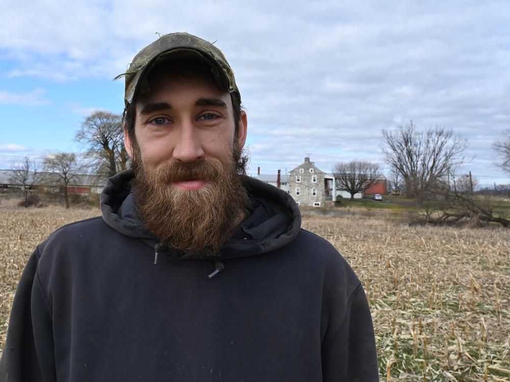 Smiling bearded man in a ballcap and hooded sweatshirt