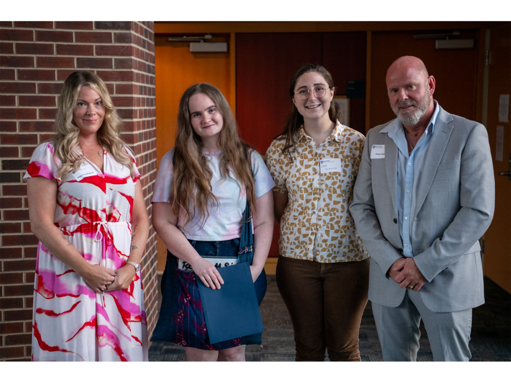Be More Lovisa Graduate Student Scholarship recipients Šárka Blahnik (center left) and Emma Steinebronn (center right) stand with the parents of Lovisa Arnesson-Cronhamre, Maja Cronhamre (far left) and Peter Arnesson Gyld (far right).