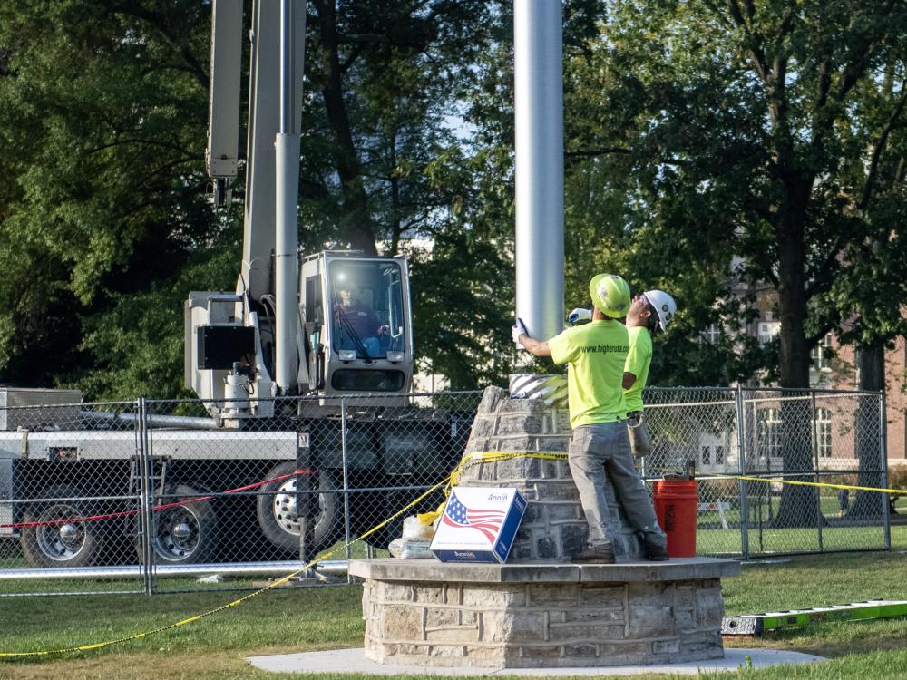 guiding new flag pole into base