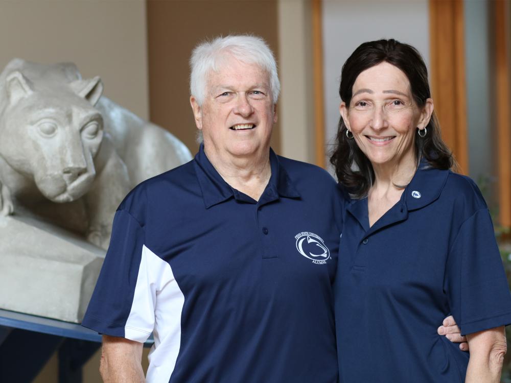 Jo Anne and John Carrick pose in front of the Nittany Lion Shrine